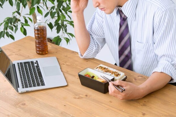 食べながら仕事する男性