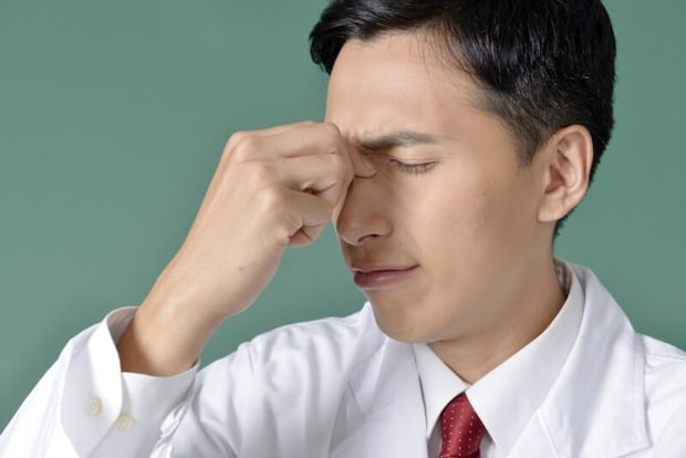 眉間を抑える男性