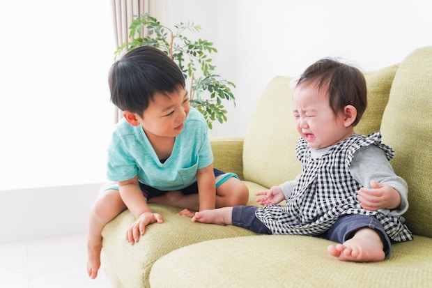 泣く赤ちゃんに話しかける男の子