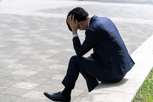 頭を抱えて悩む男性