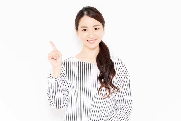 指でポイントを指し示すカジュアルな服装の女性