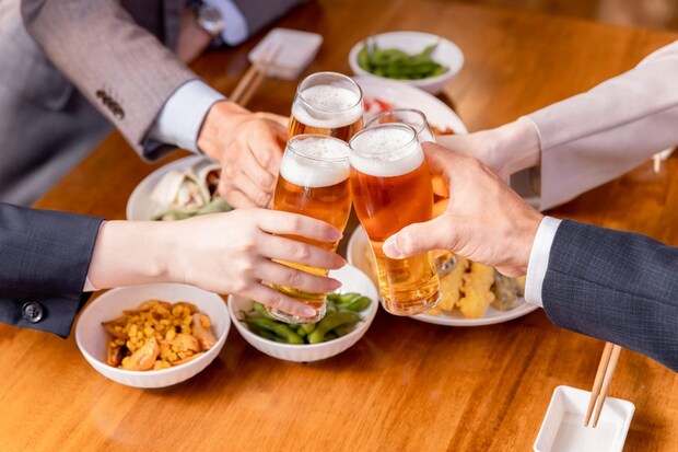 居酒屋で飲み会をする仕事仲間の男女