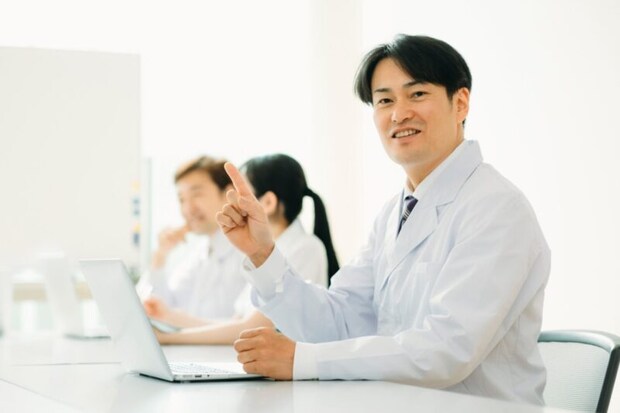 白衣を着た男性（パソコン・笑顔）