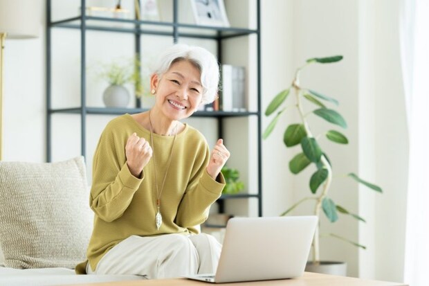リビングでパソコンを使うシニアの女性