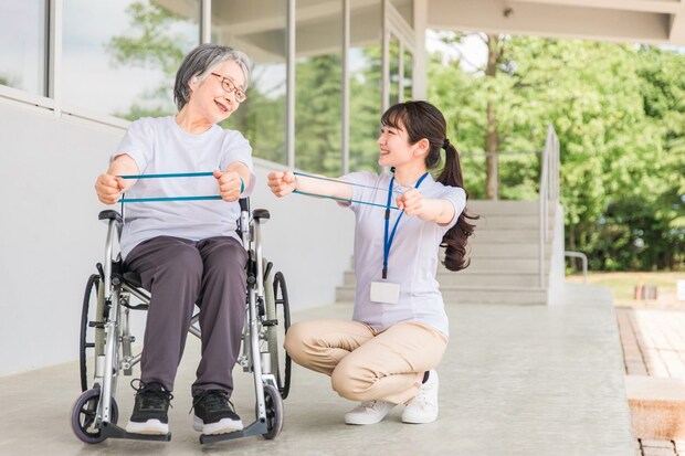 腕のリハビリをする高齢者女性と理学療法士