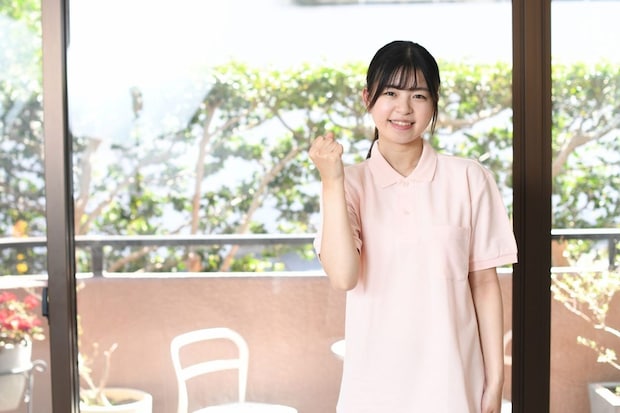 ガッツポーズをする笑顔の女性介護士