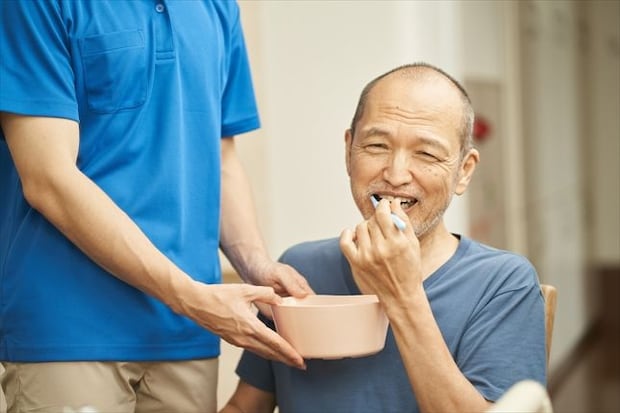 口腔ケアをする介護士と高齢者
