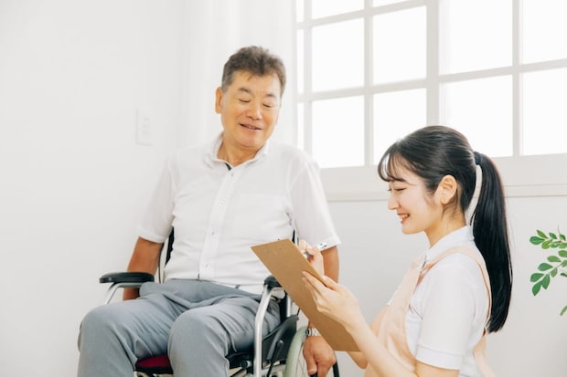 齢者男性と話す介護士