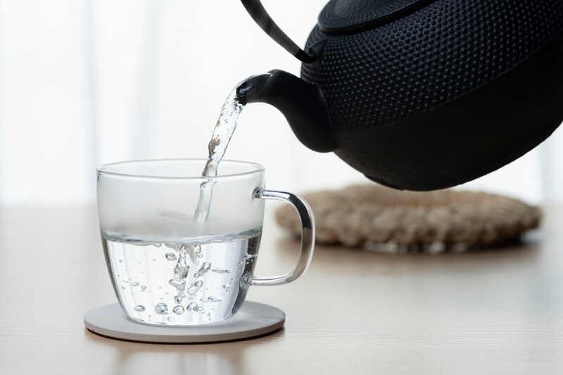 やかんで耐熱カップに熱湯を注ぐ