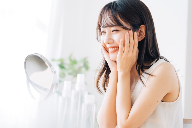 楽しそうにスキンケアする女性