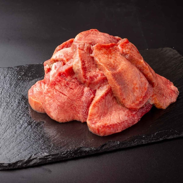 黒いお皿に盛りつけた焼く前の肉厚牛たん塩味