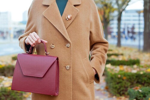 ブローチとバッグを身につけた女性