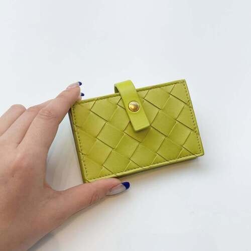 ボッテガ・ヴェネタのパスケースを持つ女性の手元