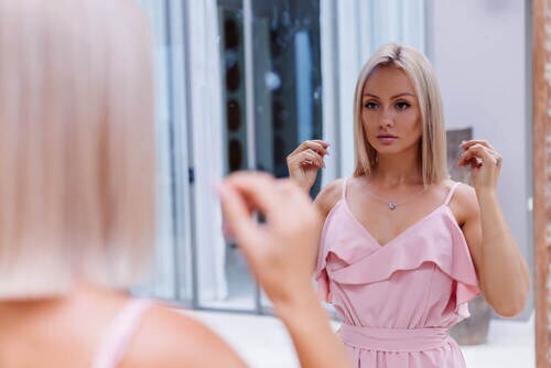 鏡を見ながらネックレスを試着する女性