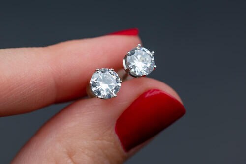 一粒ダイヤモンドピアスを持つ女性の手元