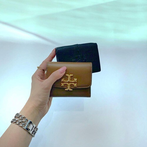 トリーバーチの財布を持つ女性の手元