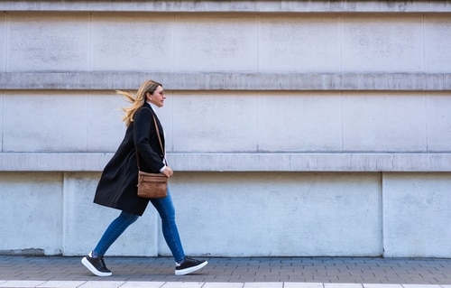 コンパクトなショルダーバッグを持ち歩く女性