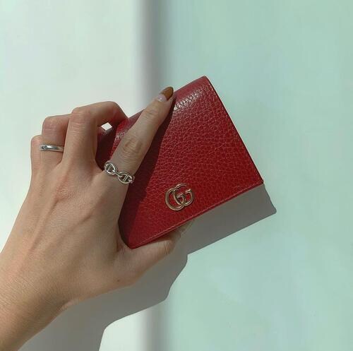 グッチの財布を持つ女性