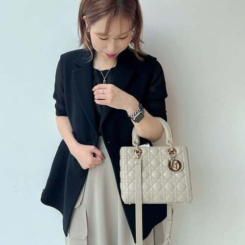 レディ ディオールの白いバッグを持つ女性