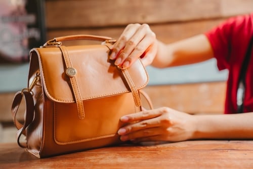 木のテーブルの上に置かれた革製のバッグ