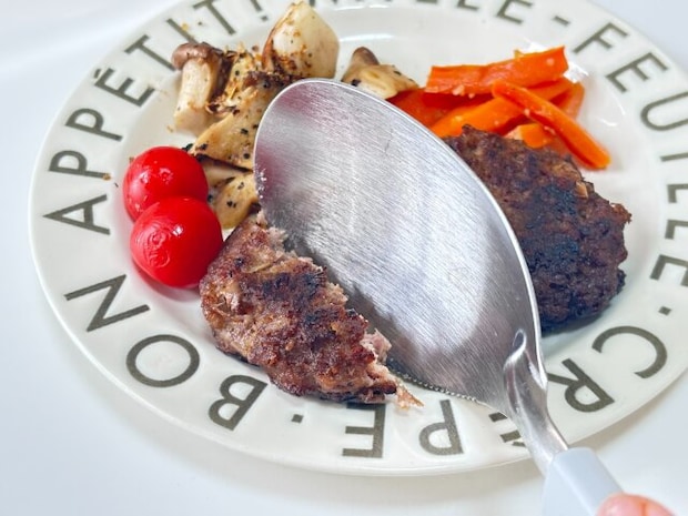 セリアのカットして取り分けられるスプーンでハンバーグを切る