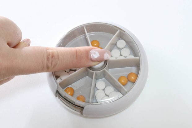 スリーコインズの回転ピルケースのボタンを押す