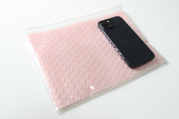 ダイソーのプチプチポーチ（ハート、27.2cm×20cm）とスマホの比較