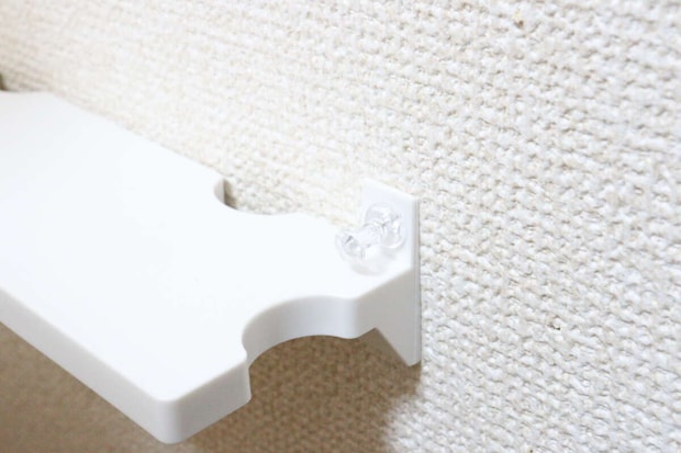 セリアのルーターラック 壁掛け ピン固定タイプにピンを刺す様子