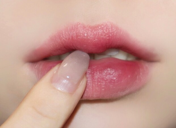 唇の中心から外側に向かって指でポンポン馴染ませながら塗る