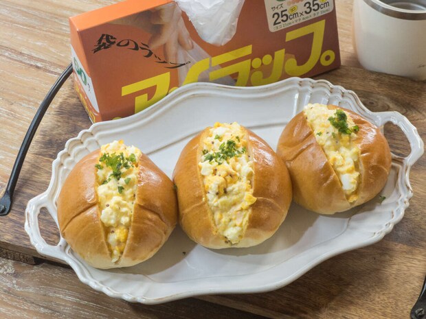 アイラップの箱を背景に白いトレーに卵サラダ入りロールパン3個とパセリをのせた完成品の俯瞰写真