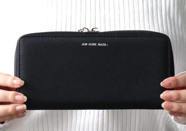 女性が黒いJAM HOME MADEのダブルジップ長財布を両手で持って見せている様子