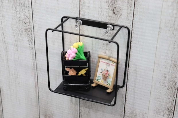 黒いアイアン壁掛け収納が木目調の白い壁に取り付けられミニチュア雑貨が飾られている 黒いアイアン壁掛け収納が木目調の白い壁に取り付けられミニチュア雑貨が飾られている