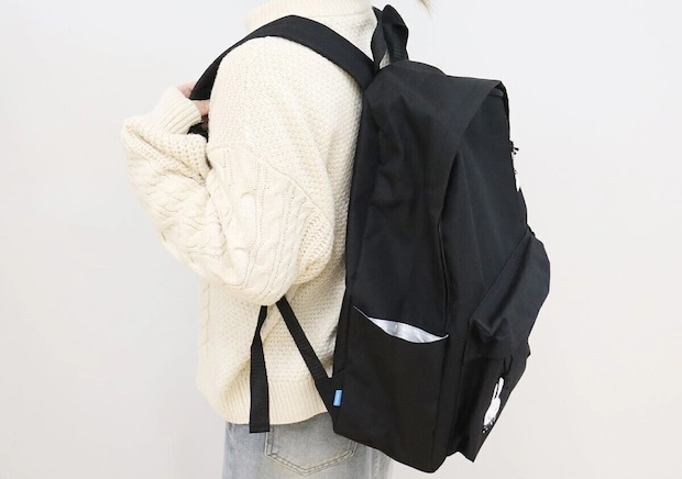 白いケーブルニットの女性がCUNE×smart黒バックパックを背負った後ろ姿