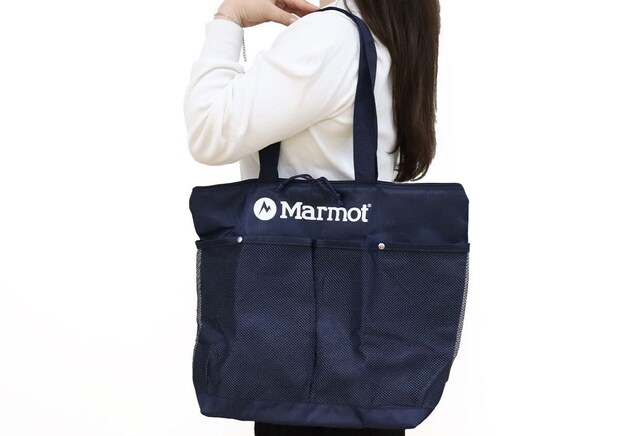 白トップスとロングヘアの女性が右手でMarmotネイビートートを肩にかける後ろ姿