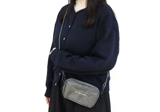 ネイビーのジャケットと白いハイネックの女性がsnow peakのグレーお財布ショルダーを斜め掛けした着用イメージ