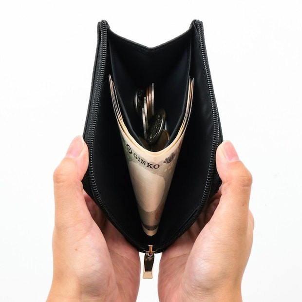 BLACKのATAOミニ財布を両手でL字に大きく開き、内側に折りたたんだ1万円札と小銭が収まっている様子の正面写真