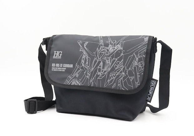 Xiガンダムデザインの黒いメッセンジャーバッグの正面写真 HGロゴとRX-105 XI GUNDAMの文字、ガンダムのラインアートがプリントされた黒いメッセンジャーバッグの正面写真