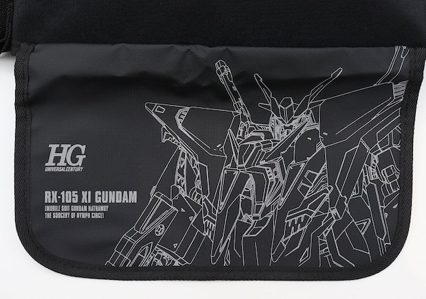 メッセンジャーバッグのフタ部分にHG UNIVERSAL CENTURY・RX-105 XI GUNDAMの文字とガンダムのリフレクタープリントが入った正面アップ写真