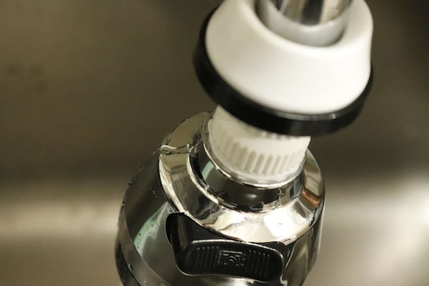 ダイソーの浄水蛇口用首ふりキットの隙間から水が漏れる様子