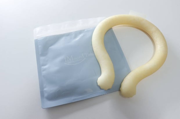 水色の保冷剤付ジップバッグの横に白いネックリングが置かれている