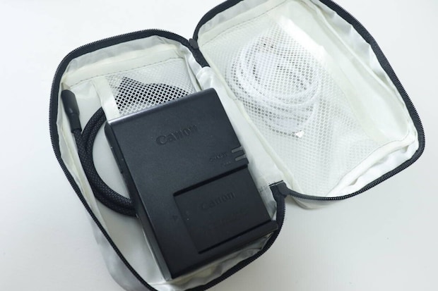 グレーのポーチにカメラバッテリーと充電ケーブルを収納している様子 グレーのポーチにカメラバッテリーと充電ケーブルを収納している様子