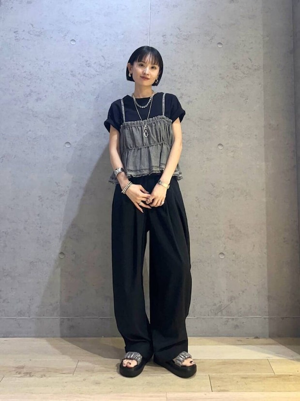 黒Tと黒ワイドパンツにデニムビスチェを重ね着した女性 黒Tと黒ワイドパンツにデニムビスチェを重ね着した女性