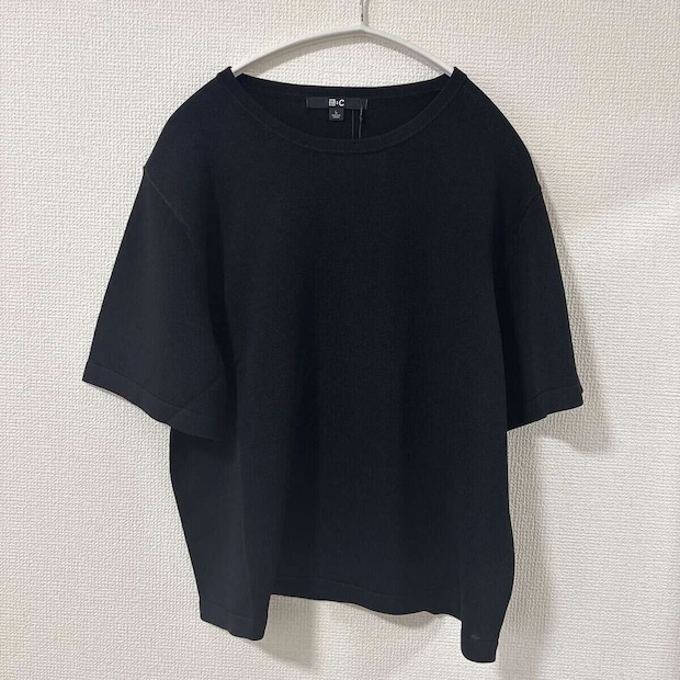 黒いボクシーニットTがハンガーにかけられ、タグが見える 黒いボクシーニットTがハンガーにかけられ、タグが見える