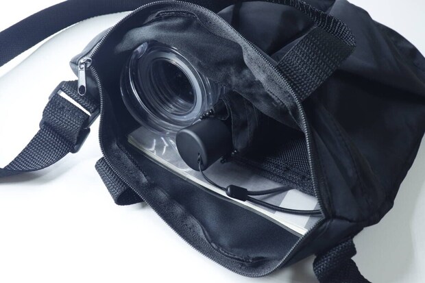 黒い2WAYショルダーバッグのメイン収納に長財布や水筒などが入っている様子