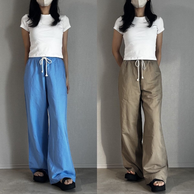 白Tシャツとブルー・ベージュパンツを履いた女性の全身正面