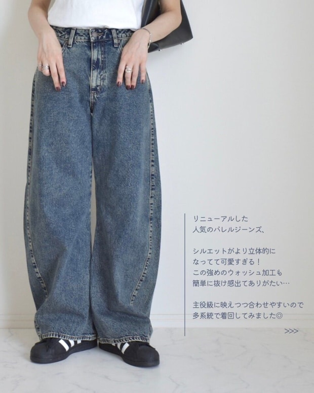 女性がGUの3Dバレルジーンズと黒いスニーカーを着用 女性がGUの3Dバレルジーンズと黒いスニーカーを着用