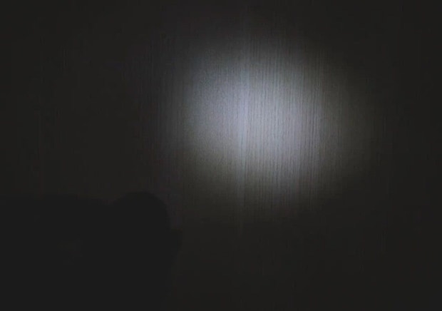 暗い部屋の壁をLEDライトの光が丸く照らしている