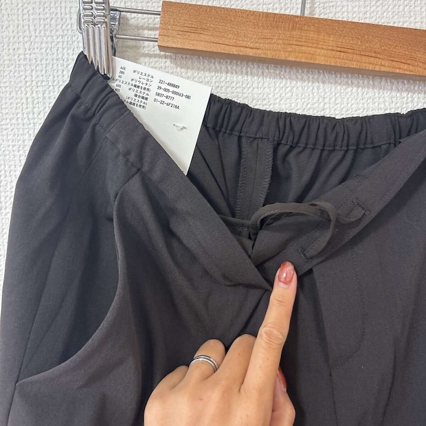 女性の指がパンツのウエスト内側の紐を指しているクローズアップ 女性の指がパンツのウエスト内側の紐を指しているクローズアップ
