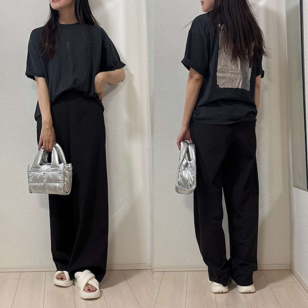 黒Tシャツと黒パンツのカジュアルコーデ。女性がシルバーのバッグを持つ 黒Tシャツと黒パンツのカジュアルコーデ。女性がシルバーのバッグを持つ