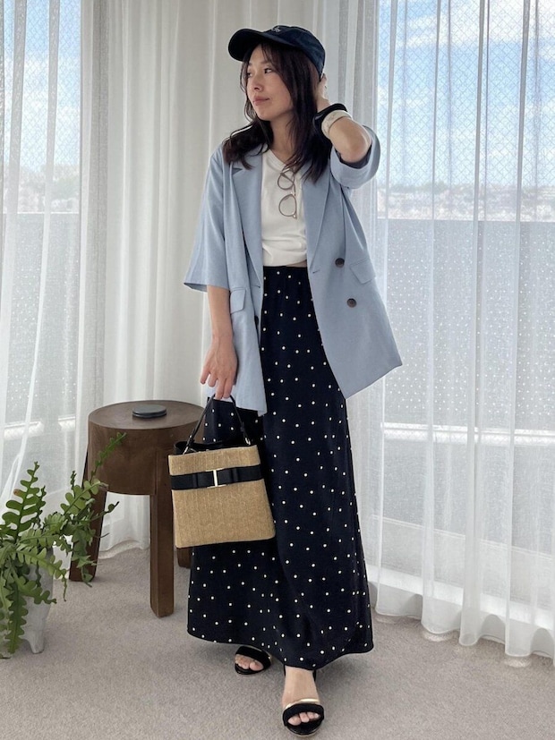黒ドット柄スカートに水色ジャケットとキャップを被った女性 黒ドット柄スカートに水色ジャケットとキャップを被った女性